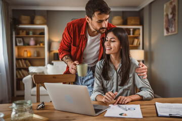 Woman work from home on laptop while boyfriend hug and support her