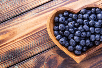 Fresh blueberries on heart-shaped plates on a wooden table