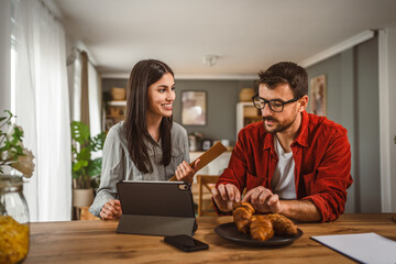 Couple prepare documents for work have coffee and breakfast at home
