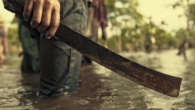 man with machete in the river forest water	
