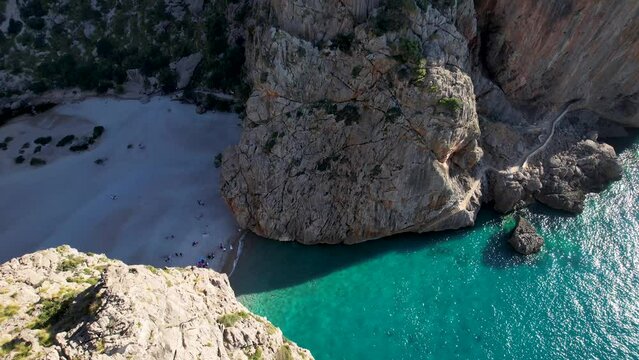 4K Aerial Drone video of unique beach carved into the canyon with turquoise blue water and boats anchored, Sa Calobra Beach, Mallorca, Spain