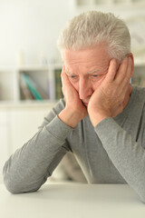 close-up portrait of a senior man thinking about something