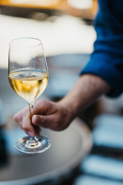 man holds a glass of sparkling white wine