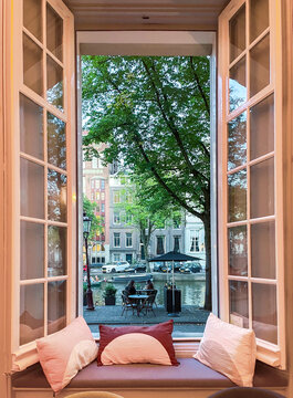 Open window with a sofa bench with canal view