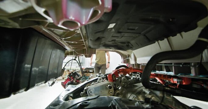 Mechanic inspecting and repairing the disassembled electric car engine. Modern electric vehicle maintenance and service. EV repair concept. Auto Service, Electric Car Battery Handling.