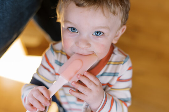 cute toddler chewing on a spatula at home