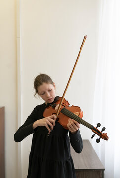 girl playing the violin in the classroom