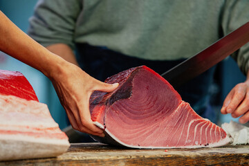Fishmonger cutting fish at Fish Market