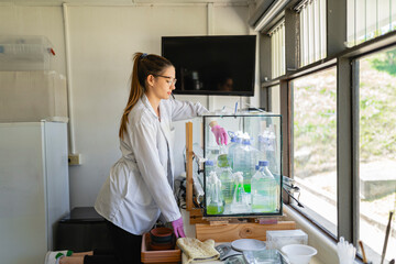 Clinical laboratory scientist picking up bottle of chemical from box