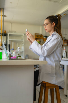 Female scientist using smartphone in laboratory