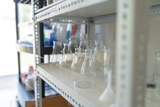 Empty conical flasks arranged on shelf in chemistry laboratory