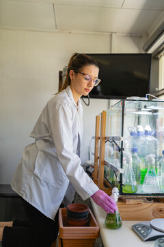 Female pharmacist conducting test with chemical in conical flask