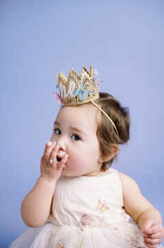 portrait of happy baby eating first cake on birthday