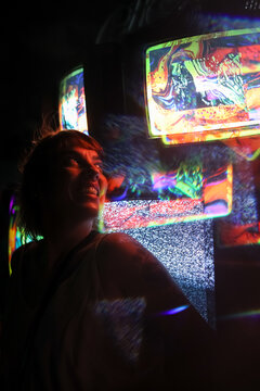 Woman standing in front of colorful abstract art screens and smiling