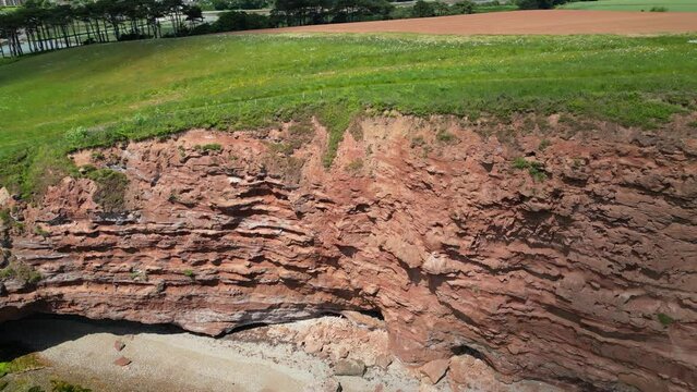 Budleigh Salterton, Devon, England: DRONE VIEWS: Red sandstone cliffs of the World Heritage Site Jurassic Coast; River Otter & farm fields. The Jurassic Coast is a popular UK holiday destination (1).