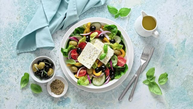 Greek salad. Horiatiki salad. Vegetable salad with feta cheese, tomato, olives, cucumber, bell pepper, lettuce, red onion and olive oil. Mediterranean cuisine. Healthy food. Stock video 4k