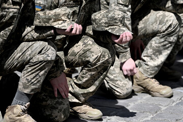 Ukrainian soldiers kneel during funerals ceremony. memorial service. War in Ukraine