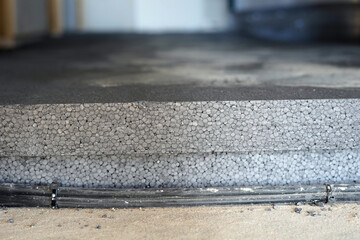 Individual layers on the floor. We see concrete, electrical wires and then two layers of polystyrene.