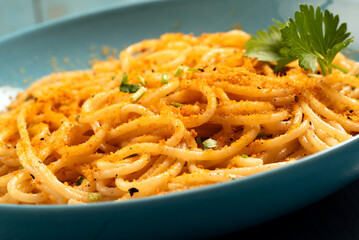 Piatto di spaghetti conditi con bottarga di muggine in polvere, pasta italiana, cibo mediterraneo 