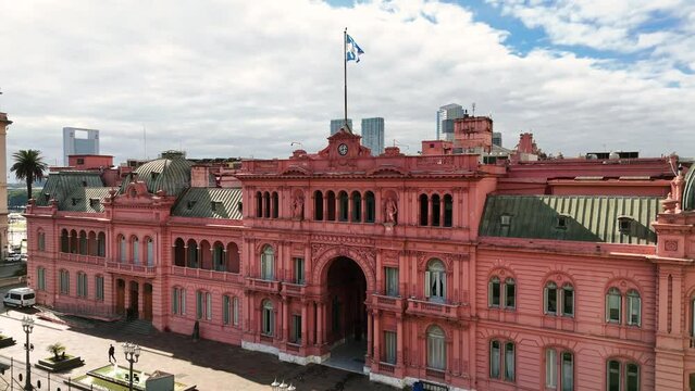 Facade of the government house Casa Rosada. Aerial camera rises revealing Puerto Madero buildings in the background