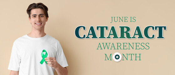 Young man with green ribbon on beige background. Glaucoma awareness month