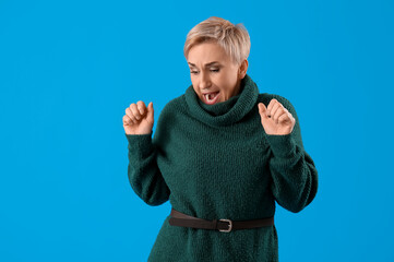 Scared mature woman on light blue background