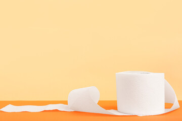 Roll of toilet paper on orange background