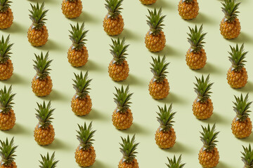 Seamless pattern of pineapples in diagonal rows over beige background