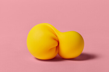 Handicraft made of yellow slime with sticky content on pink surface