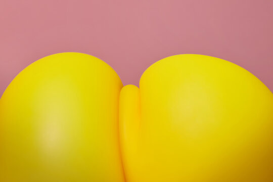 Yellow latex balloon pressurised and squeezed to two parts