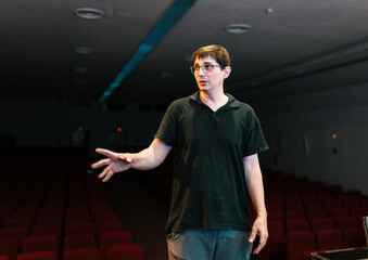 Man standing in empty auditorium and looking away