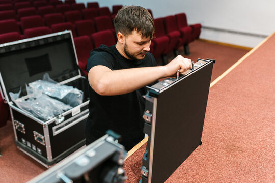 Audiovisual technician handling electronic equipment