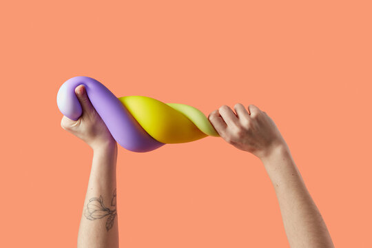 Caucasian person wringing elastic squishes on studio background