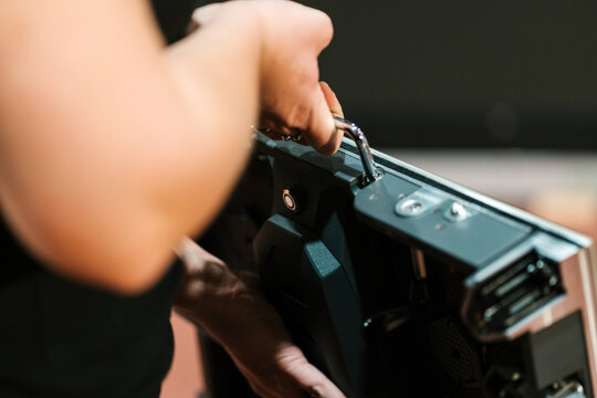 Anonymous worker installing LED panel on stage