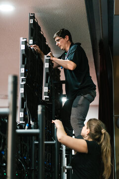 Woman worker handing over videowall panel to colleague
