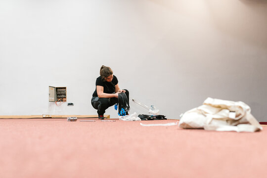 Young woman preparing cable connections in room