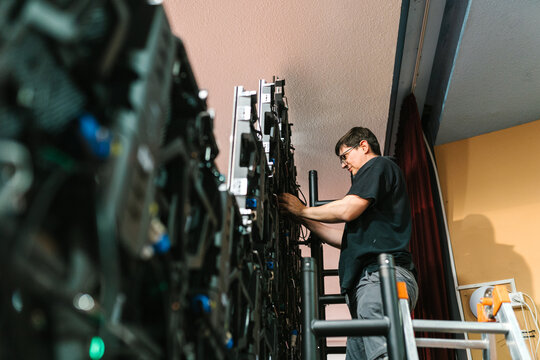 Concentrated technician working on LED panel while mounting video wall