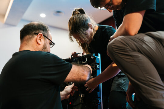 Technicians working together on LED panel on stage