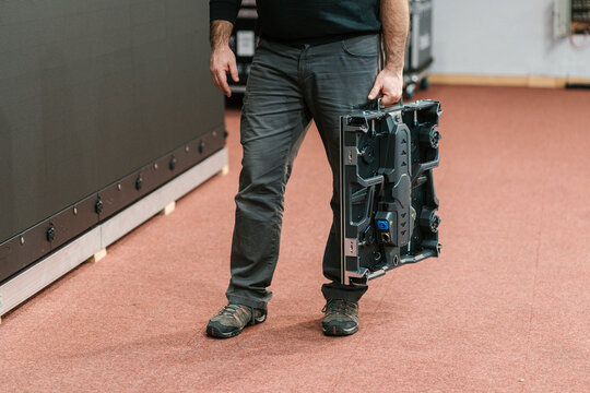 Unrecognizable technician standing in workplace with LED panel