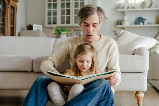 Father and daughter reading aloud together