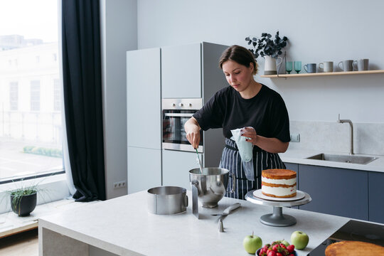 Woman Baking Cake in Kitchen