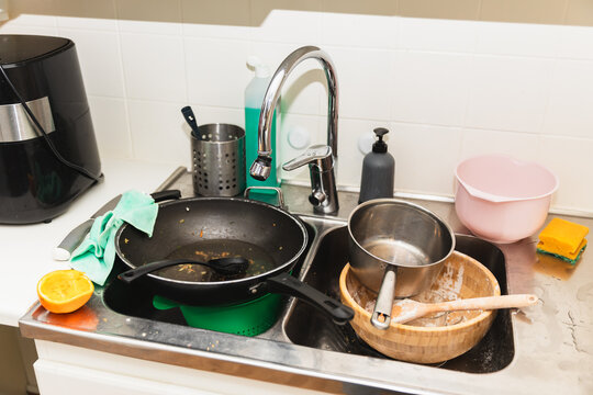Pile of dirty dishes in sink