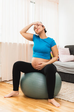 Pregnant woman sitting on a pilates ball