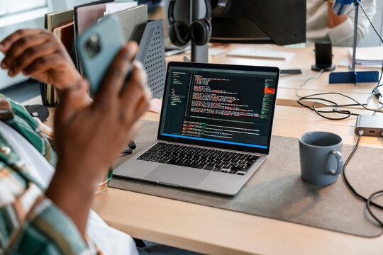 A man is programming on a laptop in the office