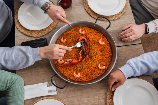 Friends sharing traditional seafood paella meal