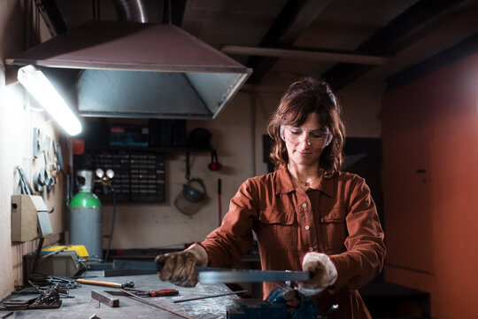 Confident worker shaping metal piece