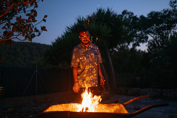 Man Smiling by Outdoor Nighttime Fire