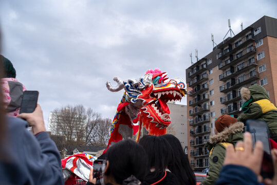 Crowd photographing dragon dance with phones