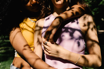 Detail of a lesbian couple holding hands while embracing