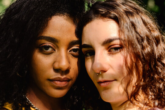 Portrait facing the camera of curly-haired women of different culture